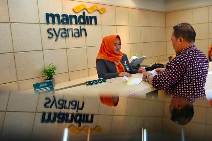 Karyawan melayani nasabah saat transaksi di Kantor Cabang Mandiri Syariah Thamrin, Jakarta, Senin (25/2/2019). - Bisnis/Abdullah Azzam