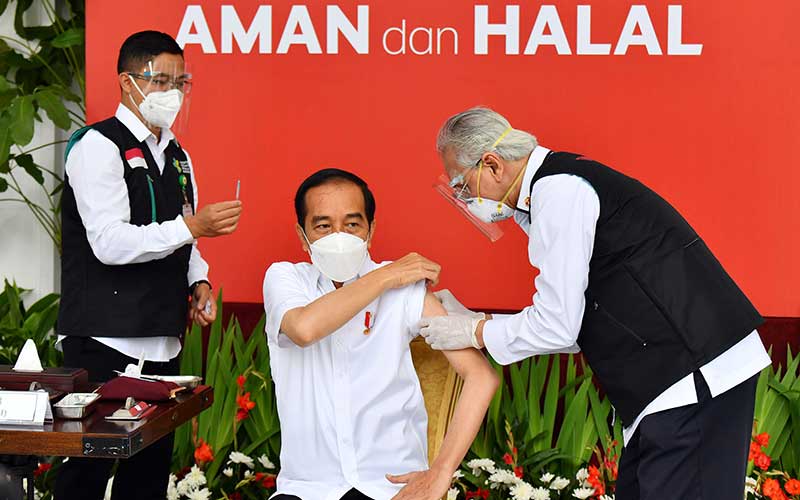 Presiden Joko Widodo (tengah) bersiap disuntik dosis pertama vaksin Covid-19 produksi Sinovac oleh vaksinator Wakil Ketua Dokter Kepresidenan Abdul Mutalib (kanan) di beranda Istana Merdeka, Jakarta, Rabu (13/1/2021). Penyuntikan perdana vaksin Covid-19 ke Presiden Joko Widodo tersebut menandai dimulainya program vaksinasi di Indonesia. ANTARA FOTO/HO - Setpres/Agus Suparto