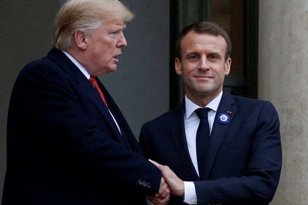 Presiden Prancis Emmanuel Macron (kanan) bersalaman dengan Presiden AS Donald Trump setelah melakukan pertemuan di Istana Elysee di Paris pada Sabtu (10/11/2018). - Reuters/Vincent Kessler
