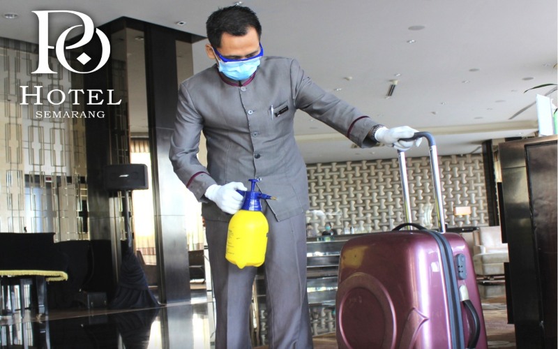 Petugas concierge PO Hotel Semarang menyemprotkan disinfektan ke barang bawaan tamu sebelum mengantarnya ke kamar.