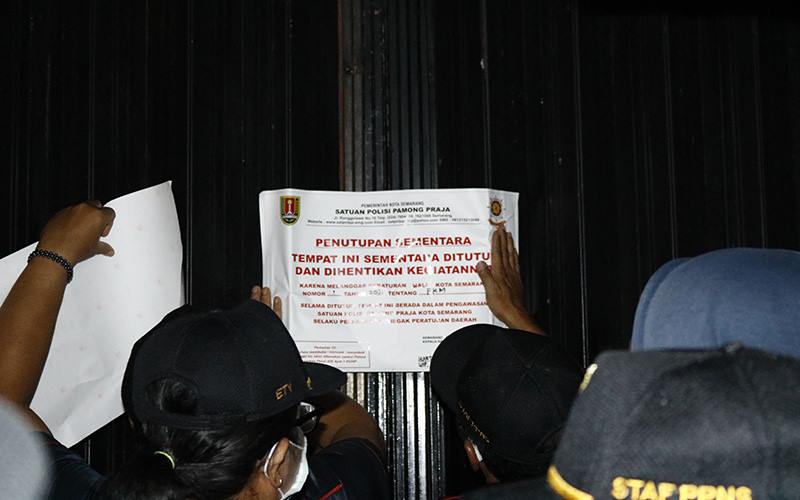 Petugas Satpol PP Kota Semarang menutup tempat usaha yang melanggar ketentuan PPKM, Rabu (13/1/2021). JIBI - Bisnis/ Muhammad Faisal Nur Ikhsan 