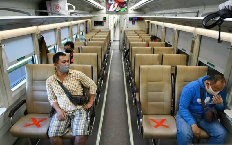 Sejumlah penumpang dengan mengenakan masker di dalam gerbong kereta api luar biasa relasi Gambir-Surabaya Pasar Turi lintas selatan di Stasiun Gambir, Jakarta. - Antara