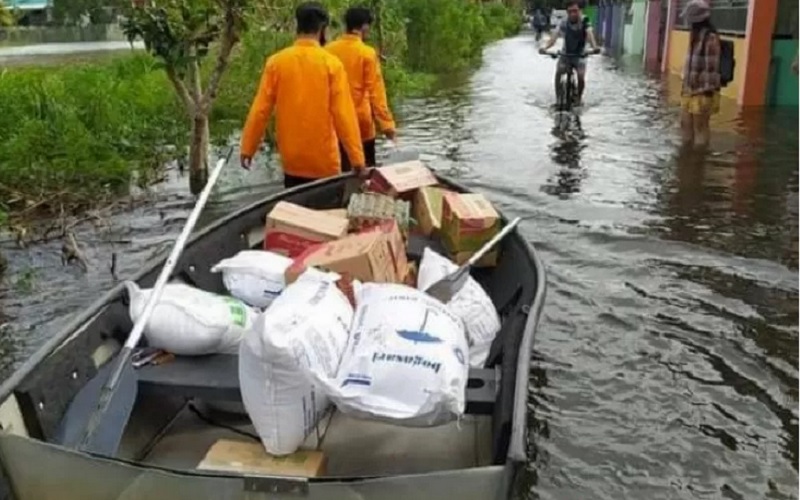Para anggota BPBD Kota Banjarmasin, Kalsel, Rabu (20/1/2021) menggunakan perahu saat mengantar bantuan untuk warga terdampak banjir. - Antara