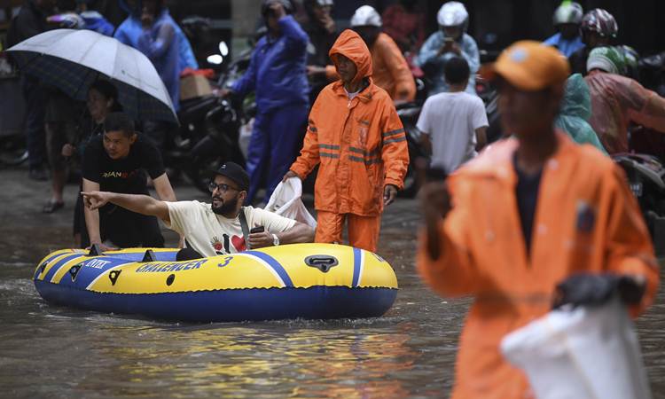 Warga menaiki perahu karet saat melintasi banjir di kawasan Kemang Raya, Jakarta, Selasa (25/2/2020). Tingginya intensitas hujan mengakibatkan sejumlah wilayah di ibu kota terendam banjir. - ANTARA/Wahyu Putro A