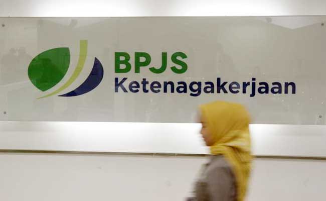 Karyawan melintas di dekat logo BPJS Ketenagakerjaan/BP Jamsostek di Jakarta. - Bisnis/Himawan L Nugraha