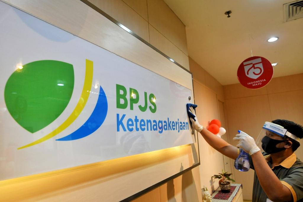 Petugas kebersihan membersihkan logo BPJS Ketenagakerjaan di Jakarta, Rabu (26 - 8).