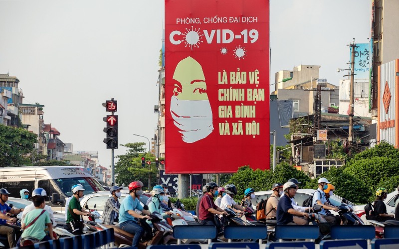 Papan iklan besar berisi pemberitahuan tentang virus corona terpampang di jalanan Hanoi, Vietnam, Jumat (29/5/2020). - Bloomberg/Maika Elan
