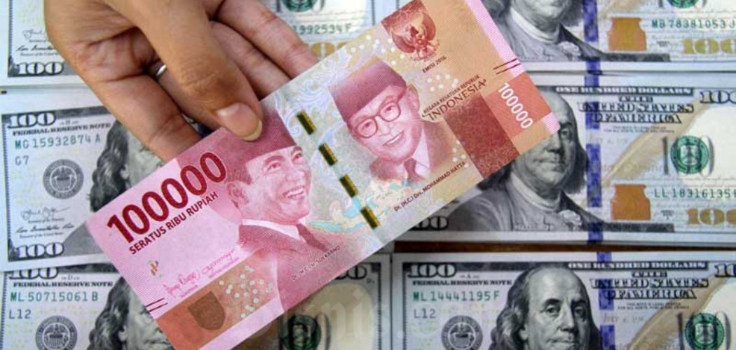 Petugas menunjukkan uang rupiah dan dolar AS di salah satu gerai penukaran mata uang asing di Jakarta, Senin (16/3/2020). - Bisnis/Arief Hermawan P 