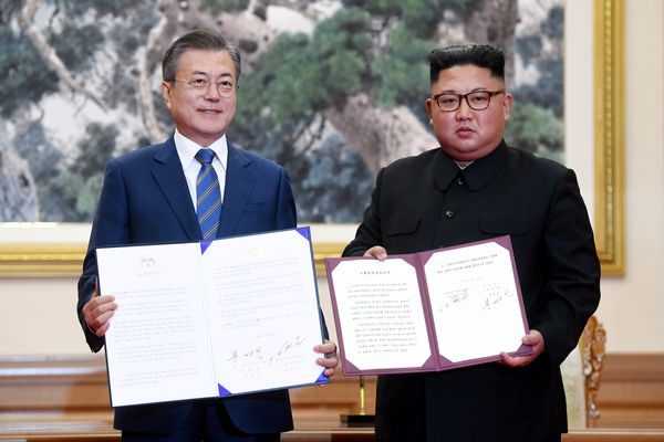 Presiden Korea Selatan Moon Jae-in dan pemimpin tertinggi Korea Utara Kim Jong Un menunjukkan pernyataan bersama kedua negara di Pyongyang, Korea Utara, Rabu (19/9). - Pyeongyang Press Corps via Reuters
