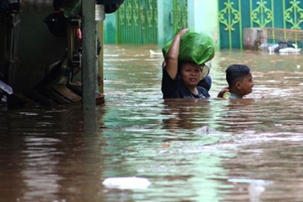 Banjir Kampung Pulo Warga berjalan menembus banjir yang melanda kawasan Kampung Pulo, Jakarta - Antara