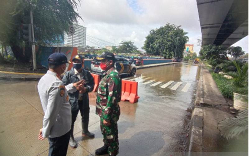 Petugas melakukan rekayasa lalu lintas akibat luapan Kali Ciliwung di kawasan Pademangan, Jakarta Utara, Senin (8/2/2021)./Antara/HO - Humas Pemkot Jakarta Utara