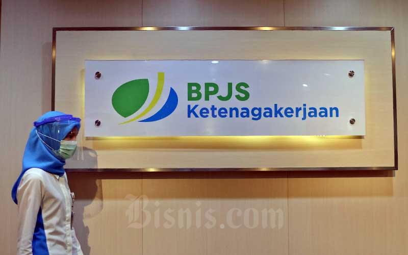 Pegawai melintasi logo BPJS Ketenagakerjaan di Kantor Cabang BP Jamsostek di Menara Jamsostek, Jakarta, Jumat (10/7/2020). Bisnis - Eusebio Chrysnamurti