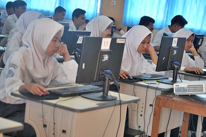 Sejumlah siswa mengerjakan soal pada Ujian Nasional Berbasis Komputer (UNBK) Sekolah Menengah Atas Kejuruan (SMK) di ruang komputer Gedung SMK Negeri 7 Palembang, Sumatra Selatan, Senin (25/3/2019). - ANTARA/Feny Selly
