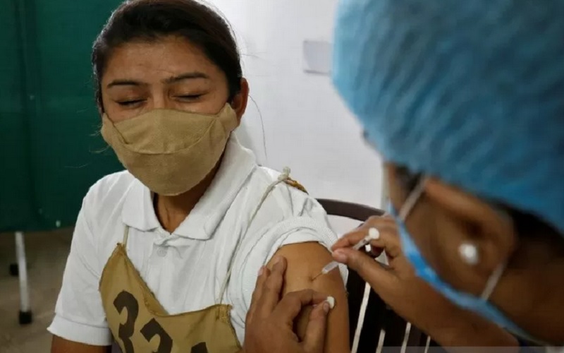 Seorang polisi wanita bereaksi saat menerima suntikan vaksin Covid-19, COVISHIELD yang diproduksi oleh Institut Serum India, di Rumah Sakit Umum di Ahmedabad, India, Minggu (31/1/2021). - Reuters/Antara\r\n