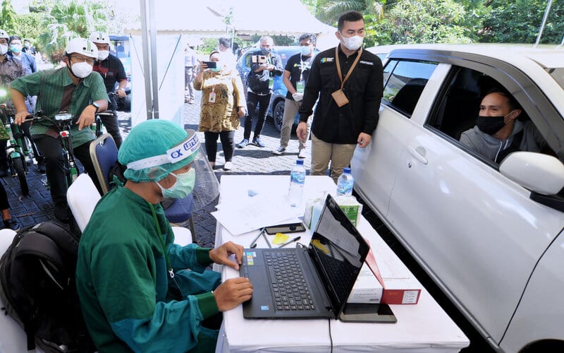 Menteri Kesehatan Budi Gunadi Sadikin (kiri) meninjau pelaksanaan vaksinasi Covid-19 dengan sistem 'drive thru' di Nusa Dua, Badung, Bali, Minggu (28/2/2021). - Antara/Fikri Yusuf.