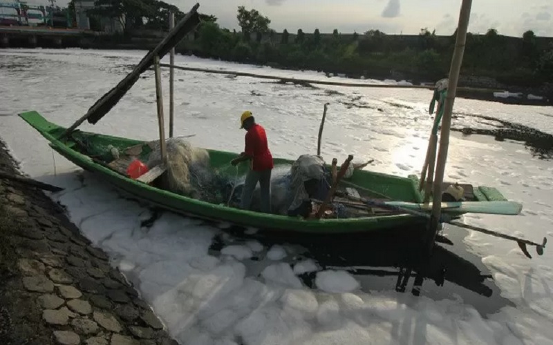 Nelayan beraktivitas di muara Sungai Tambak Wedi yang permukaannya penuh busa putih di Surabaya, Jawa Timur, Minggu (29/3/2020). - Antara