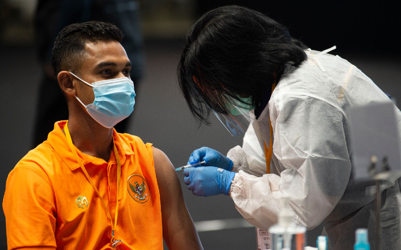 Petugas menyuntikkan vaksin Covid-19 kepada pesepak bola Timnas sepak bola U-23 Miftahul Hamdi (kiri) di Istora Senayan, Gelora Bung Karno (GBK), Jakarta, Jumat (26/2/2021).  - ANTARA\r\n