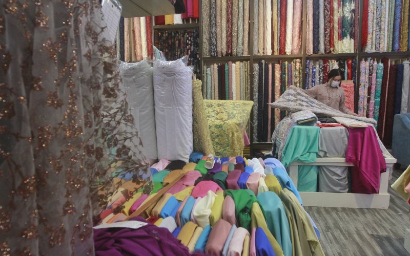 Pedagang merapikan kain di salah satu gerai di Pasar Tanah Abang, Jakarta, Selasa (8/12/2020).  - Bisnis.com/Himawan L Nugraha