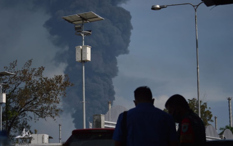 Warga menyaksikan kepulan asap hitam dari lokasi kebakaran kilang Balongan - Bisnis/Hakim Baihaqi