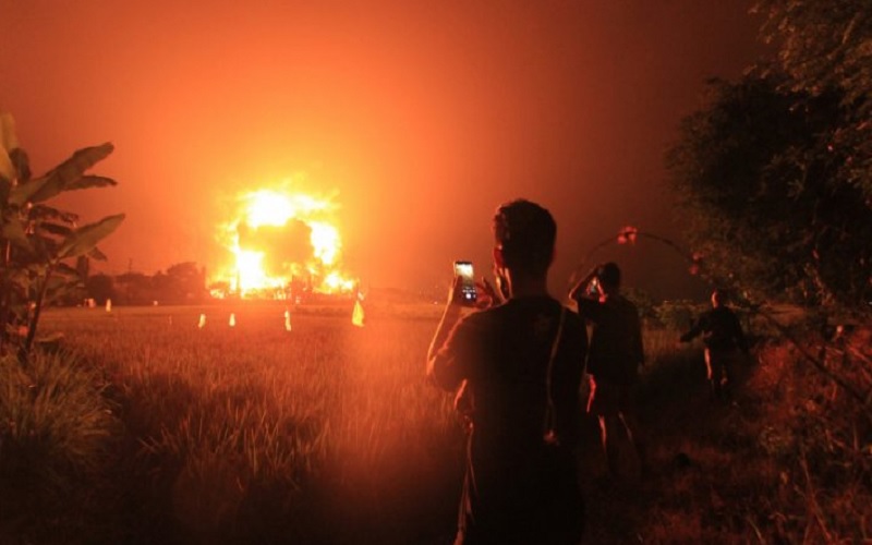 Warga menyaksikan kebakaran di kompleks Pertamina RU VI Balongan, Indramayu, Jawa Barat, Senin (29/3/2021) dini hari. - Antara