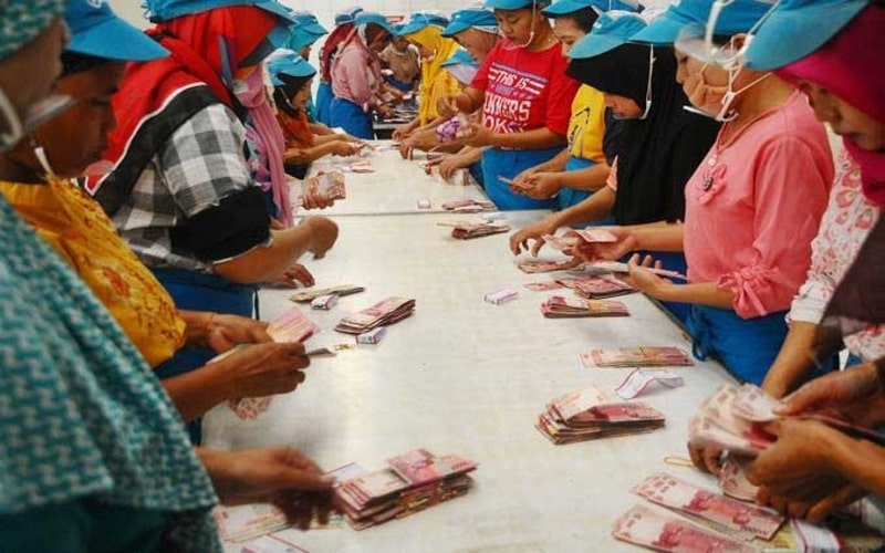 Sejumlah pekerja pabrik rokok menghitung uang Tunjangan Hari Raya (THR) Lebaran saat pembagian di Kudus, Jawa Tengah, Selasa (21/5/2019). - ANTARA/Yusuf Nugroho