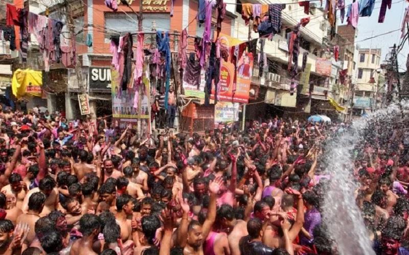 Para pria bersorak saat mereka disiram air selama perayaan Holi, di tengah penyebaran Covid-19 di Prayagraj, India, Senin (29/3/2021). - Antara/Reuters