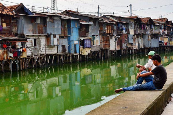 Warga memancing di Sungai Grogol yang bantarannya dipenuhi rumah kumuh di Jalan Tanjung Selor, Grogol, Jakarta Barat, Jumat (24/3). - Antara/Atika Fauziyyah