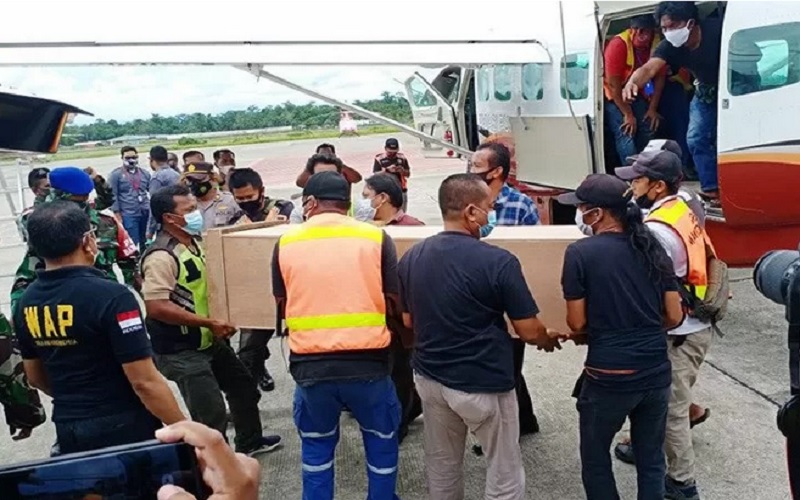 Peti jenazah dua guru korban korban penembakan oleh KKB diturunkan dari pesawat Dabi Air dan dimasukan ke dalam mobil ambulans untuk dibawa ke kamar jenazah RSUD Mimika, Sabtu (10/4/2021). - Antara