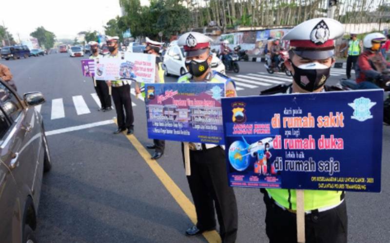 Ilustrasi - Polisi membawa poster saat kampanye larangan mudik di kawasan Terminal Madureso, Temanggung, Jateng, Rabu (21/4/2021). - Antara/Anis Efizudin