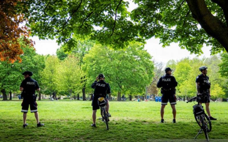 Ilustrasi - Polisi Toronto berjaga di Trinity Bellwoods Park saat pemerintah provinsi bersiap untuk fase selanjutnya pembukaan kembali dari pembatasan akibat wabah penyakit virus Corona (COVID-19) di Toronto, Ontario, Kanada, Minggu (24/5/2020). - Antara/Reuters/Carlos Osorio
