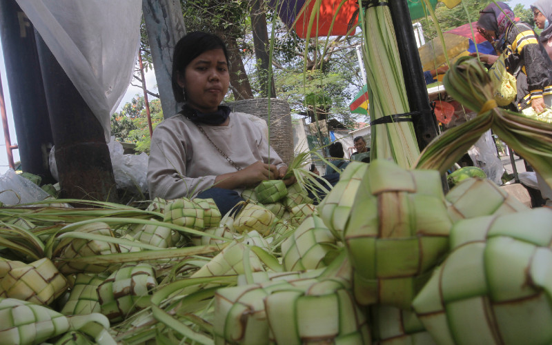 Pedagang membuat kulit ketupat di salah satu pasar di Jakarta, Selasa (11/5/2021). Menjelang hari Idulfitri, marak pedagang kulit ketupat musiman menggelar dagangannya di pasar-pasar hingga ke tepi jalan. Harganya Rp10.000-Rp15.000 per 10 unit.  - Bisnis/Himawan L Nugraha