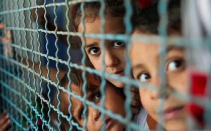 Anak-anak Palestina, yang meninggalkan rumah mereka untuk menghindari serangan udara dan artileri Israel, melihat melalui jendela sekolah yang dikelola PBB tempat mereka mengungsi di Kota Gaza, Selasa (18/5/2021). - Antara/Reuters