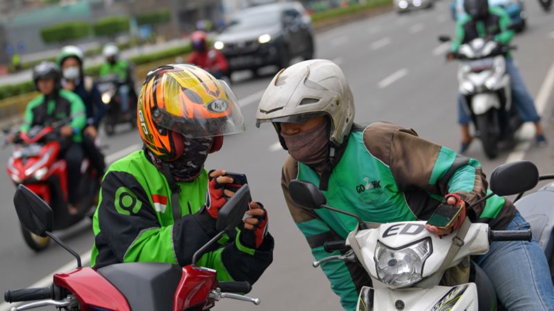Dua orang pengemudi ojek online berbincang di Jalan Thamrin, Jakarta, Senin (17/2/2020). - ANTARA / M Risyal Hidayat\n