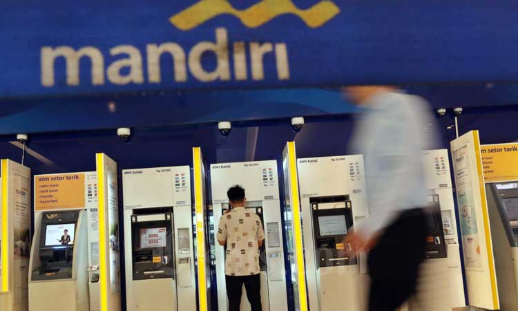 Nasabah mengambil uang di Anjungan Tunai Mandiri (ATM) Bank Mandiri di nJakarta, Selasa (10/3/2020). Bisnis - Eusebio Chrysnamurti