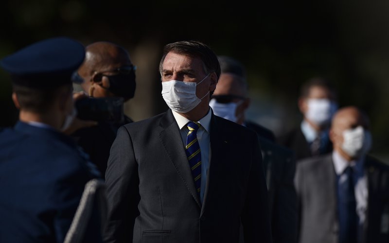 Presiden Brazil Jair Bolsonaro mengunakan masker saat Upacara Bendera di Istana Alvorada di Brasilia. - Bloomberg / Andre Borges