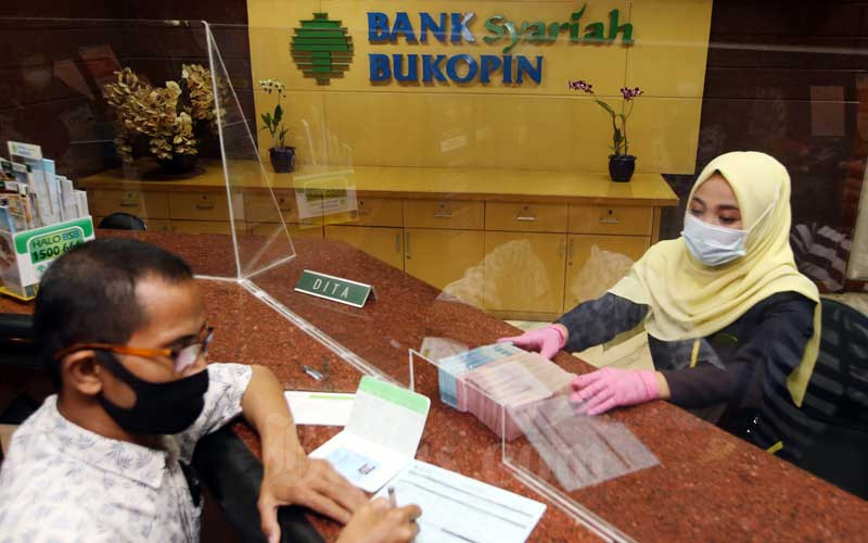 Karyawan melayani nasabah yang akan membuka deposito di Bank Bukopin Syariah, Jakarta, Kamis (11/2/2021). Bisnis - Abdullah Azzam