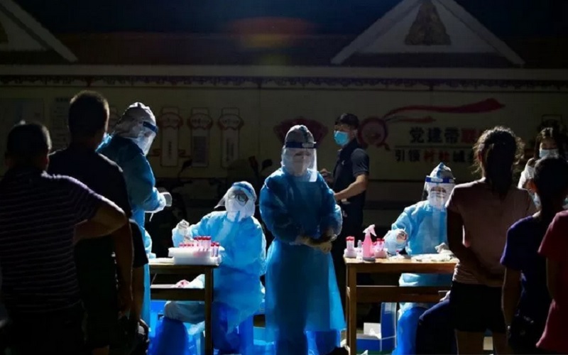 Tenaga medis dengan alat pelindung diri menghadapi warga yang mengantre untuk uji asam nukleat di sebuah halaman perumahan, menyusul kasus impor Covid-19 dari negara tetangga Myanmar, di kota perbatasan Ruili, prefektur Dehong, provinsi Yunnan, China, Rabu (16/9/2020). - Antara/Reuters\r\n