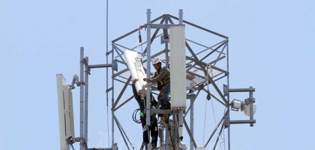 Teknisi memasang perangkat Base Transceiver Station (BTS) di salah satu tower di Makassar, Sulawesi Selatan, Rabu (18/3/2020). - Bisnis/Paulus Tandi Bone