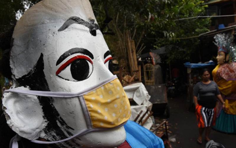 Ondel-ondel dipasangi masker di kawasan Kramat Pulo, Jakarta - Antara/Indrianto Eko Suwarso