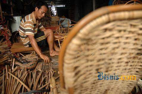 Seorang pria sedang menganyam kursi dari kulit bambu. - ilustrasi