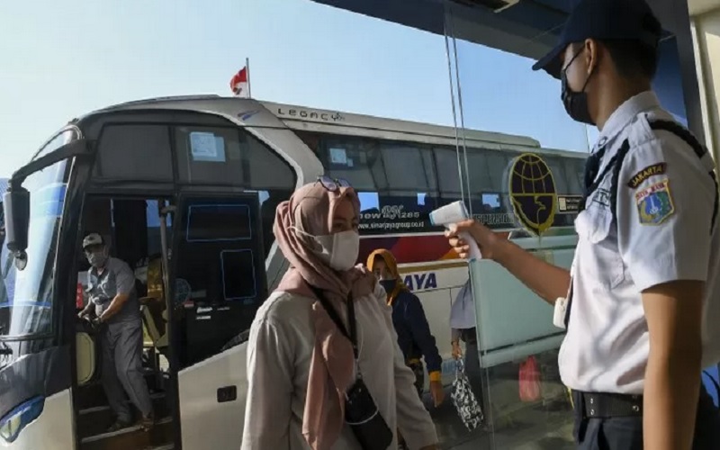 Petugas memeriksa suhu tubuh dari pemudik saat tiba di Terminal Terpadu Pulo Gebang, Jakarta Timur, Sabtu (15/5/2021). - Antara
