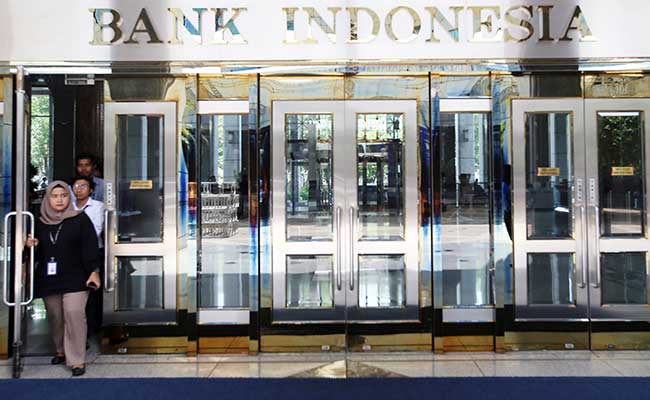 Karyawan melintas didekat logo Bank Indonesia di Jakarta, Senin (30/12/2019). Bisnis - Abdullah Azzam