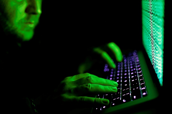 Ilustrasi seorang pria sedang mengetik kode siber. - Reuters/Kacper Pempe