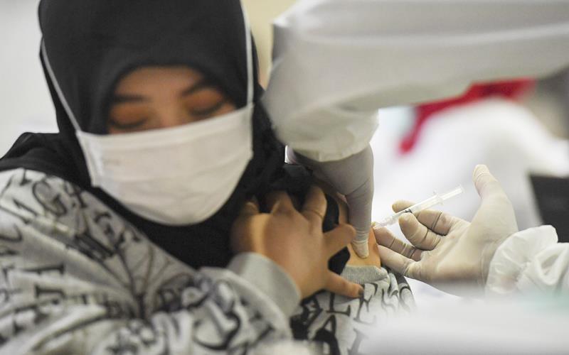 Petugas menyuntikan vaksin Covid-19 kepada pedagang di Pasar Tanah Abang Blok A, Jakarta, Rabu (17/2/2021). Vaksinasi Covid-19 tahap kedua yang diberikan untuk pekerja publik dan lansia itu dimulai dari pedagang Pasar Tanah Abang. ANTARA FOTO - Hafidz Mubarak A