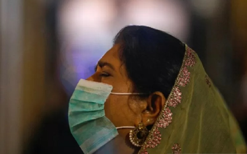 Seorang perempuan memakai masker saat menghadiri layanan malam Natal di St Andrew's Church, ketika penyebaran penyakit  Covid-19 terus berlanjut, di Karachi, Pakistan, Kamis (24/12/2020). Foto diambil tanggal 24 Desember 2020. - Antara/Reuters
