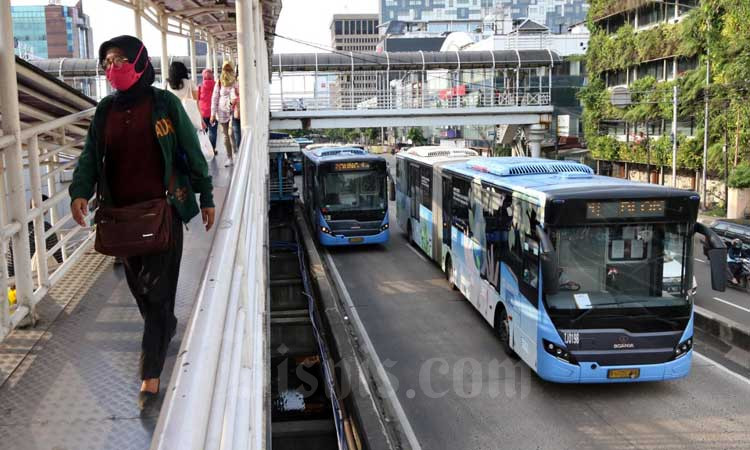 Penumpang melewati tangga untuk menaiki bus transjakarta di Halte Harmoni, Jakarta, Selasa (3/3/2020). Bisnis - Eusebio Chrysnamurti
