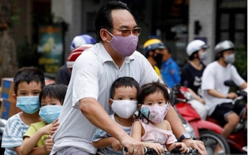 Dokumentasi - Seorang pria mengendarai sepeda membawa anak-anak  melewati sebuah jalan di tengah mewabahnya virus Corona (COVID-19), di Hanoi, Vietnam, Senin (27/7/2020)./Antara - Reuters/Kham