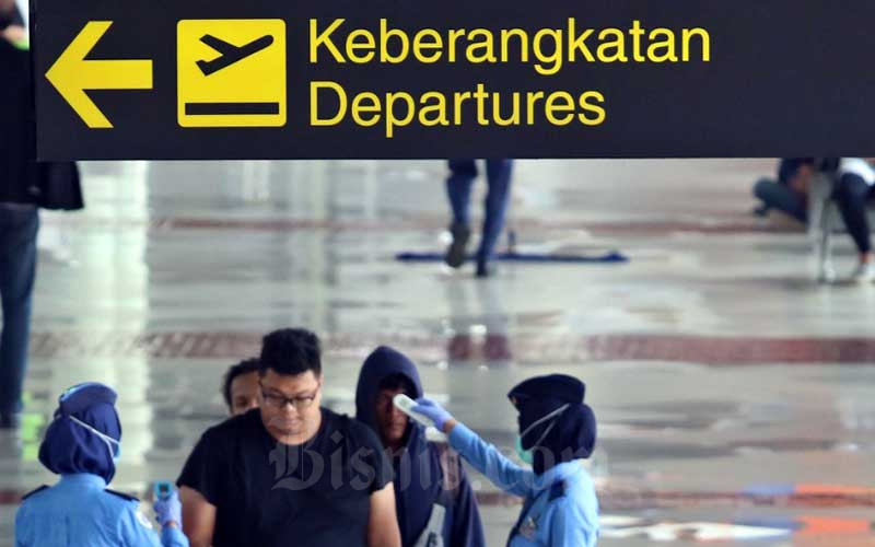 Petugas memeriksa suhu tubuh penumpang yang akan masuk di Terminal IA Bandara Soekarno Hatta, Tangerang, Banten, Selasa (17/3/2020). PT Angkasa Pura II (Persero) memprediksi jumlah penumpang pada kuartal I/2020 bisa berkurang sebesar 218.000 orang atau sekitar 1 persen dibandingkan periode yang sama pada tahun lalu akibat wabah virus corona (COVID-19) yang menyebabkan aktivitas penerbangan domestik dan internasional berkurang. Bisnis - Eusebio Chrysnamurti