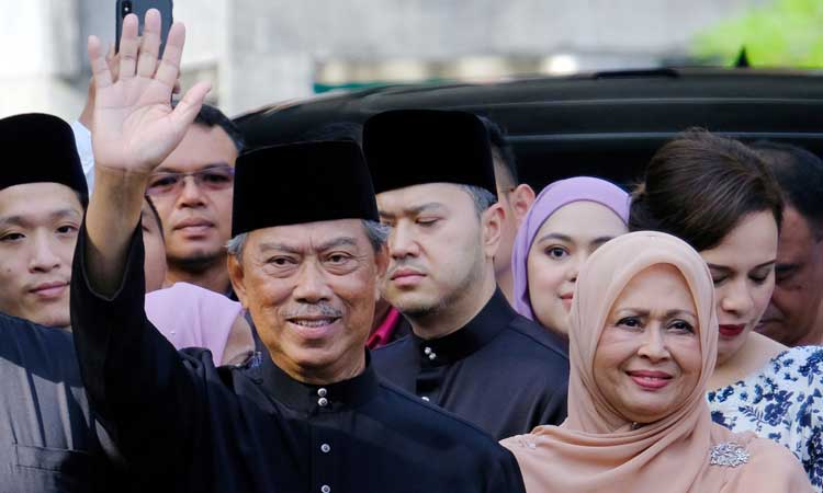 Perdana Menteri Malaysia Muhyiddin Yassin (kiri) melambaikan tangan sebelum berangkat untuk upacara pelantikan di Istana Nasional di Kuala Lumpur, Malaysia, Minggu (1/3/2020). Muhyiddin diangkat sebagai perdana menteri pada 29 Februari oleh raja negara itu untuk mengakhiri pergolakan enam hari perebutan kekuasaan setelah Mahathir Mohamad tiba-tiba mengundurkan diri pada hari Senin karena pertengkaran dalam koalisinya yang dulu. Bloomberg - Samsul Said