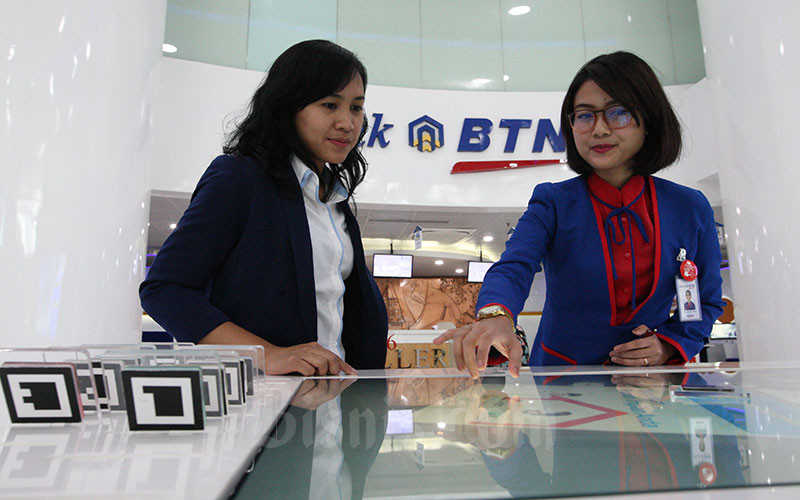 Karyawati PT Bank Tabungan Negara memberikan penjelasan mengenai produk perbankan kepada nasabah di Jakarta, Senin (8/1). Bisnis - Dedi Gunawan